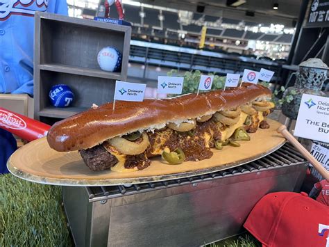 Boomstick burger - Swapping out the hot dog, the “Boomstick Burger” is a 2-foot long Nolan Ryan beef patty topped with chili, nacho cheese, jalapenos and fried onion rings on a brioche bun. The Rangers stress ...